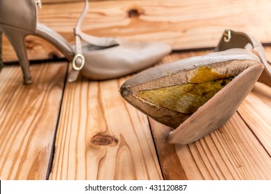 Female Broken High Heel Shoes On Wood Background