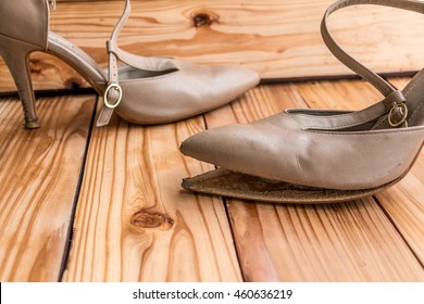 Female Broken High Heel Shoes On Wood Background