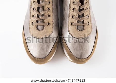 Female brown leather sneaker on white background, isolated product, comfortable footwear, top view.
