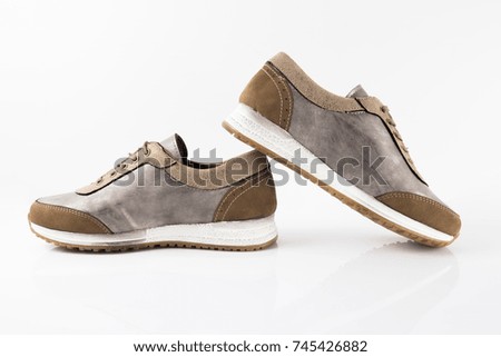 Female brown leather sneaker on white background, isolated product, comfortable footwear.