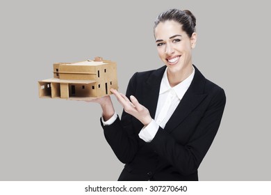 Female business agent holding house model. - Shutterstock ID 307270640