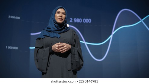 Female Business Executive Introduces New Software Product on Stage at a Conference. Arab Expert Does Motivational Talk. Speaker Having a Lecture about Science, Technology, Development, Leadership - Powered by Shutterstock