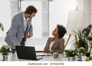 Female business leader talting to her collegue at her office - Shutterstock ID 1575616762