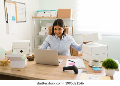 Female business owner smiling and feeling happy while preparing packages to ship to customers. Young woman with a lot of online orders