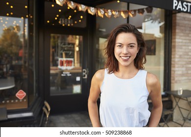 Female Business Owner Standing In The Street Outside Cafe