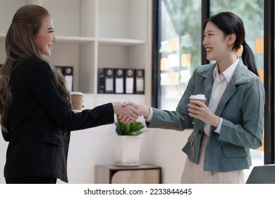 Female business worker with colleagues in Thailand working together at office desk, getting shaking hands, successful and agreement concept - Shutterstock ID 2233844645