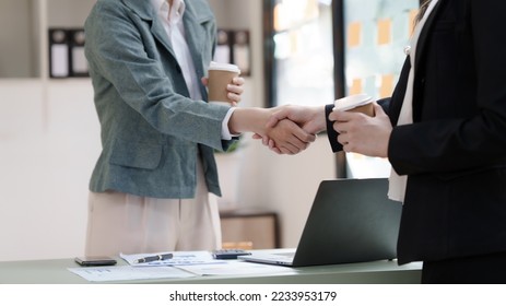 Female business worker with colleagues in Thailand working together at office desk, getting shaking hands, successful and agreement concept - Shutterstock ID 2233953179
