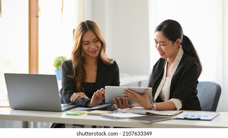 Female Business Worker With Her Colleague Planning A Marketing Campaign Project Together In Office.