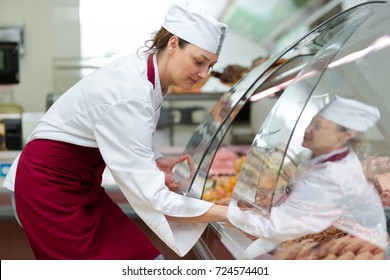 female butcher serving his customer on a grocery - Powered by Shutterstock