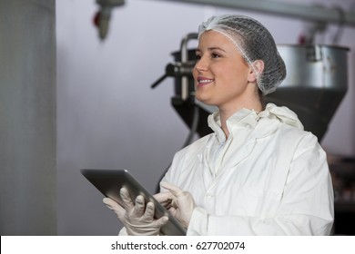 Female butcher using digital tablet at meat factory - Powered by Shutterstock