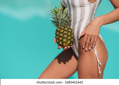 Female Buttocks In White Swimsuit, Sexy Ass. Young Sporty Woman Holding A Pineapple In Her Hand