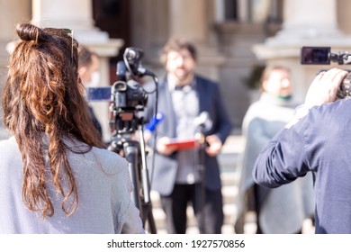 Female Camerawoman Shooting Media Event Or News Conference With A Video Camera. Public Relations - PR Concept.