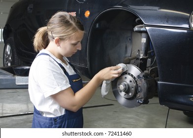 Female car mechanic in a blue overall with the wheel change - Powered by Shutterstock