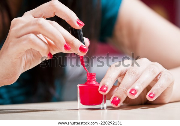 Female carefully\
painting her\
fingernails.