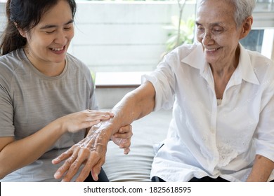 Female Caregiver Assisting To Apply Sunscreen Lotion On The Arms And Body,skin Care Cream For Elderly Sensitive Skin,happy Smiling Senior Woman With Sun Block, Protect UV Rays And Skin Cancer Concept