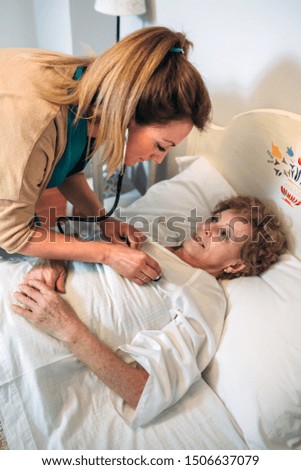 Similar – Caregiver auscultating senior woman