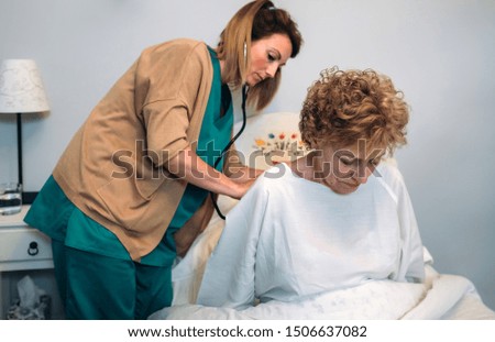 Similar – Caregiver helping elderly female patient to get out of bed