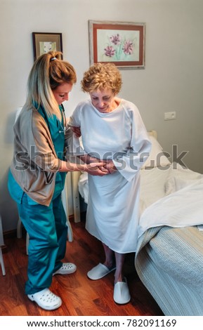 Similar – Caregiver making bed of elderly patient in nursing home