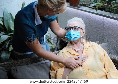 Female Caregiver with Senior Woman at geriatric Retirement Home. Professional help and support to old pensioner patient. Selective focus
