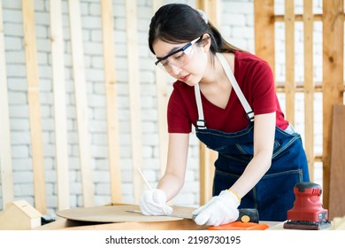 Female Carpenter Wear Eyeglasses Working With Machinist Square To Measure Of Wood In The Wood Workshop