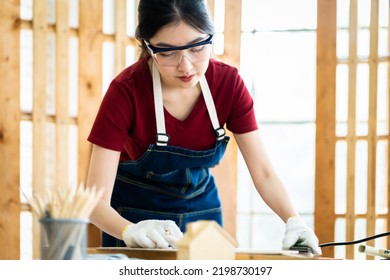 Female Carpenter Wear Eyeglasses Working With Machinist Square To Measure Of Wood In The Wood Workshop