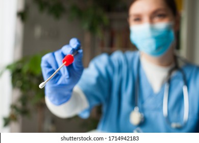 Female caucasian doctor holding a swab collection stick, nasal and oral specimen swabbing in doctor's office, patient PCR testing procedure appointment, Coronavirus COVID-19 global pandemic crisis - Shutterstock ID 1714942183