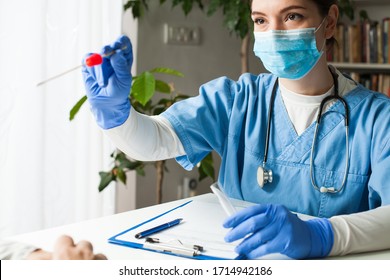 Female caucasian doctor holding a swab collection stick, nasal and oral specimen swabbing in doctor's office, patient PCR testing procedure appointment, Coronavirus COVID-19 global pandemic crisis