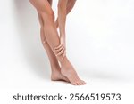 Female caucasian legs and feet on white background - focus on smooth skin and graceful stance. Skincare, daily routine, home care