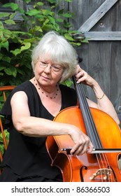 Female Cellist Performing On The Cello Outside.