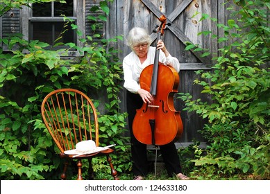 Female Cellist Standing With Her Cello Outside.