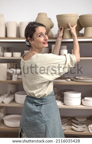 Similar – Woman in work wear in her workshop by table with handmade items