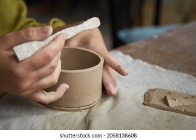 Female ceramist working in pottery studio. Ceramist's Hands Dirty Of Clay. Process of creating pottery. Master ceramist works in her studio - Powered by Shutterstock