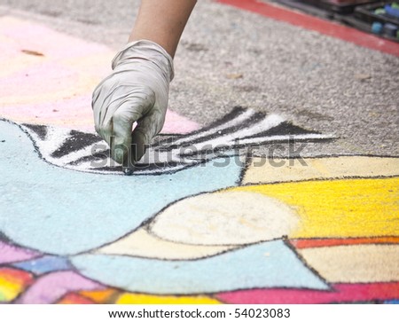 a female chalk artist working on a design