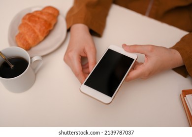 Female Chatting With Her Friends, Reading Online Content, Using Her Mobile Phone In The Cafe.