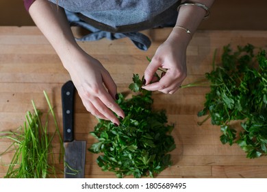 Female chef chopping fresh herbs