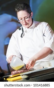 Female Chef At Cooking Demonstration On Stage.