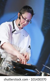 Female Chef At Cooking Demonstration On Stage.