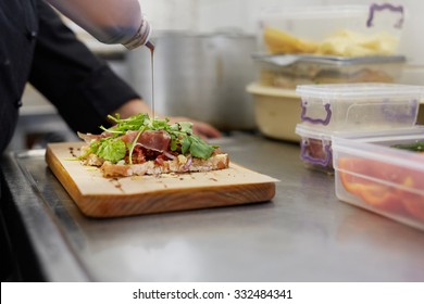 A Female Chef Drizzling Balsamic Vinegar On An Open Sandwich