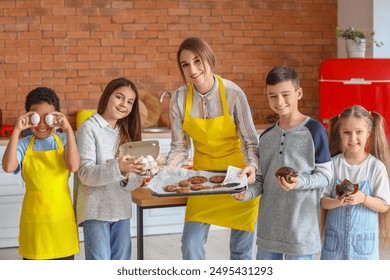 Female chef with group of little children and prepared pastry after cooking class in kitchen - Powered by Shutterstock