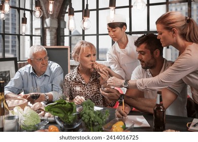 Female chef handing over food samples to students in cooking class - Powered by Shutterstock