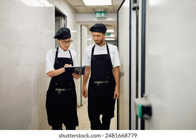 Female chef and her coworker going through order list in a restaurant. Copy space. - Powered by Shutterstock