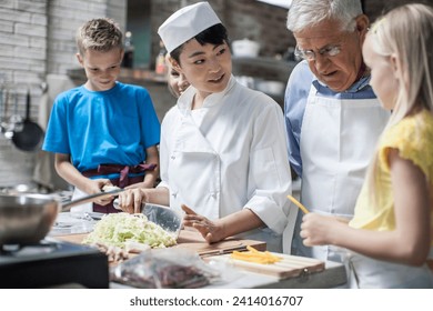 Female chef instructing kids in cooking class - Powered by Shutterstock