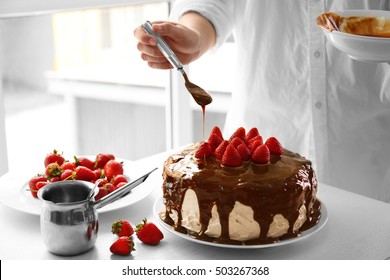 Female chef making caramel cake with strawberries