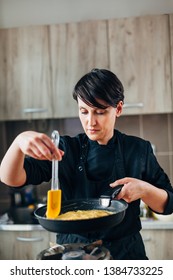 Female Chef Making Omelette On A Gas Stove