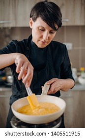 Female Chef Making Omelette On A Gas Stove