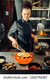 Female Chef With Pan Cooking Meat With Pasta