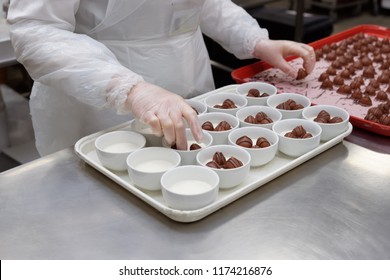 Female chef is portioning airline chocolate candy desserts in commercial kitchen - Powered by Shutterstock
