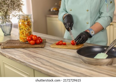 Female Chef Prepares Italian Pasta With Tomatoes And Permesan In A Bright Kitchen In A Rustic Style. Mint Coat Apron. Chef At Home