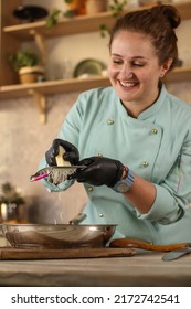 Female Chef Prepares Italian Pasta With Tomatoes And Permesan In A Bright Kitchen In A Rustic Style. Mint Coat Apron. Chef At Home