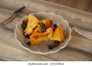 Female Chef Prepares Pancakes In A Bright Kitchen In A Rustic Style. Mint Coat Apron. Homemade Pancakes With Berries. Chef At Home